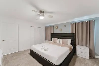 a bedroom with a large bed with white sheets at 3017 SL new 11 guests heat pool BBQ near Disney in Kissimmee