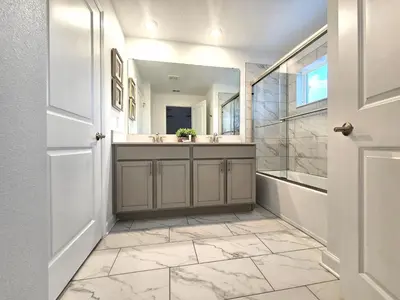 a bathroom with a sink and a tub and a mirror at 3017 SL new 11 guests heat pool BBQ near Disney in Kissimmee