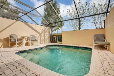 a swimming pool with two chairs and a glass ceiling at 2541 - Casa 3 Quartos/3 Banheiros | Piscina Privativa & Resort in Orlando