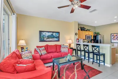 a living room with a red couch and a table at 2541 - Casa 3 Quartos/3 Banheiros | Piscina Privativa & Resort in Orlando