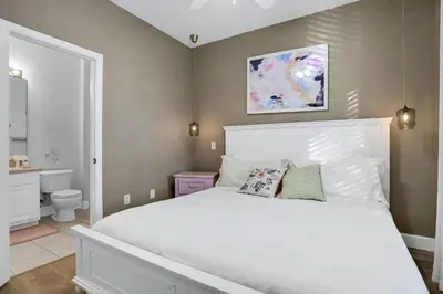a bedroom with a white bed and a bathroom at Casa 3Q Windsor Hills, Piscina + Perto da Disney in Orlando
