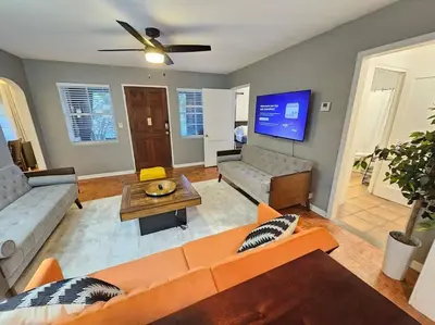a living room with a couch and a tv at Foodie Lovers Walkable Mills50 - Sleeps 10 - Near Airport in Orlando