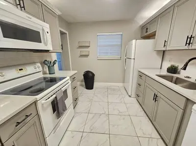 a kitchen with white appliances and white cabinets at Foodie Lovers Walkable Mills50 - Sleeps 10 - Near Airport in Orlando