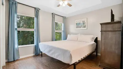 a bedroom with a bed and two windows at Family Friendly Townhome Near Attractions in Orlando