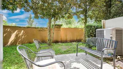 two metal benches sitting on a sidewalk in a yard at Quiet Corner Gem in Gated Crestwynd Bay in Orlando
