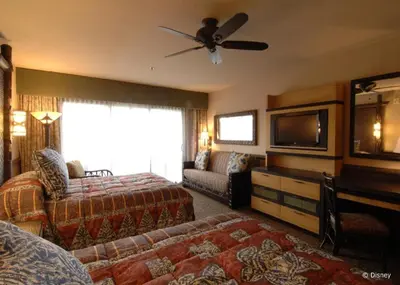 a hotel room with a bed and a flat screen tv at Disney's Polynesian Village Resort in Orlando