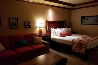 a hotel room with a bed and a couch at Disney's Polynesian Village Resort in Orlando