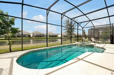 an indoor swimming pool in a house with a glass wall at Luxury 12-BR Villa w/ Pool & Resort Amenities Near Disney in Kissimmee
