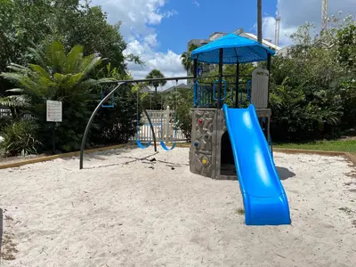 a playground with a blue slide in the sand at 15 - Amazing Vulcano Bay - Universal View in Orlando