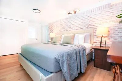 a bedroom with a bed and a brick wall at StylishAptWtrGrdnOppLake&Prk&Yrd in Orlando