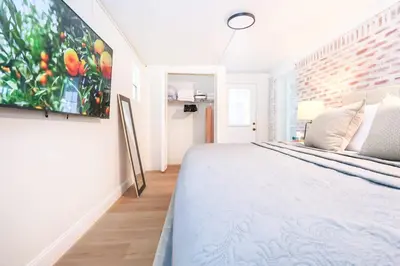 a bedroom with a bed with a painting on the wall at StylishAptWtrGrdnOppLake&Prk&Yrd in Orlando
