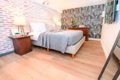 a bedroom with a bed and a brick wall at StylishAptWtrGrdnOppLake&Prk&Yrd in Orlando