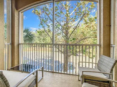 a balcony with two chairs and a large window at C2785-203-Windsor Hills Resort Free Water Park Themed Rooms in Orlando
