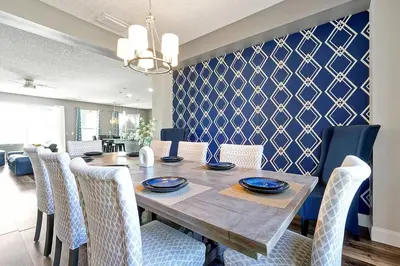 a dining room with a wooden table and chairs at Waterfront Villa showcasing a theater, games room, and a private pool in Kissimmee