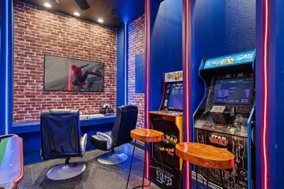 a room with a video game machine and two chairs at 6Q/4B | Piscina Privativa | Sala de Jogos Avengers in Orlando