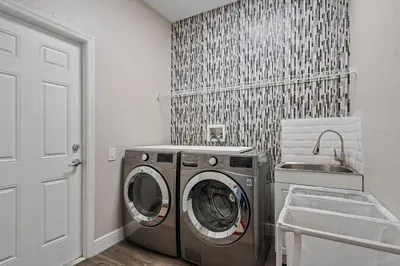a laundry room with a washing machine and a sink at 6Q/4B | Piscina Privativa | Sala de Jogos Avengers in Orlando
