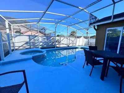 a swimming pool with a table and chairs on a patio at 3Q/2B 15 min até a Disney, Piscina, Indian Wells in Kissimmee