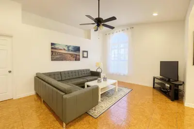a living room with a couch and a tv at 3Q/2B 15 min até a Disney, Piscina, Indian Wells in Kissimmee