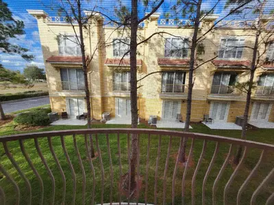 a view of a building from behind a fence at 3Q/3.5B Vista Cay Resort - 5 Minutos da Universal in Orlando