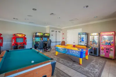 a games room with a pool table and arcade machines at 3Q/3.5B Vista Cay Resort - 5 Minutos da Universal in Orlando