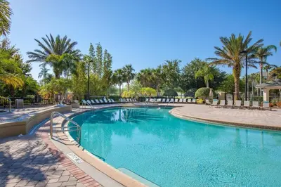 a swimming pool in a resort with palm trees at 3Q/3.5B Vista Cay Resort - 5 Minutos da Universal in Orlando