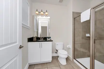 a white bathroom with a toilet and a shower at Regal Home With Private Pool Near Disney With Waterpark & Resort Access At Encore Resort - 7727Ff in Kissimmee