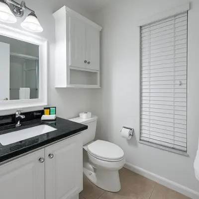 a white bathroom with a toilet and a sink at 3Q/2B Perto da DISNEY, Piscina Privativa in Kissimmee