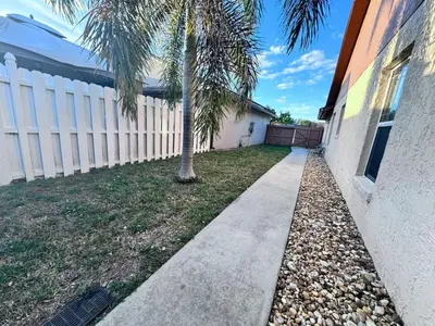 a sidewalk in front of a house with a palm tree at 3Q/2B Perto da DISNEY, Piscina Privativa in Kissimmee
