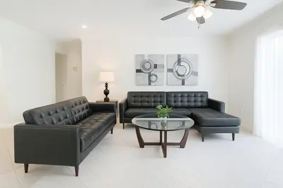 a living room with two leather couches and a table at 3Q/2B Perto da DISNEY, Piscina Privativa in Kissimmee