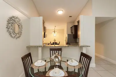 a dining room with a glass table and chairs at 3Q/2B Perto da DISNEY ☆ Piscina Priv. in Kissimmee