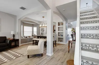 a living room and dining room with a table and chairs at Six Bedroom Disney Home Lanai Screened Pool & Spa villa in Kissimmee