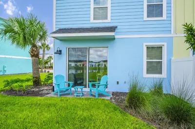 a house with blue chairs and a patio at Charming Villa Near Disney With Margaritaville Resort & Island H20 Access - 8173Su in Orlando