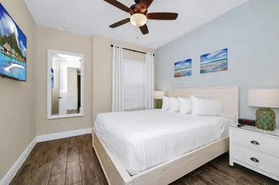 a bedroom with a white bed and a ceiling fan at Magic Vacation Villa Near Disney With Margaritaville Resort & Island H20 Waterpark Access - 2932Or in Orlando