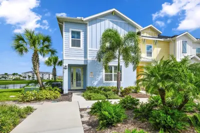 a house with palm trees in front of it at Magic Vacation Villa Near Disney With Margaritaville Resort & Island H20 Waterpark Access - 2932Or in Orlando