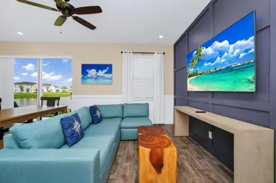 a living room with a blue couch and a tv at Magic Vacation Villa Near Disney With Margaritaville Resort & Island H20 Waterpark Access - 2932Or in Orlando