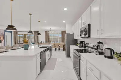 a large kitchen with white counter tops and appliances at Luxury Home - ALL the extras - Sleeps 39 in Kissimmee