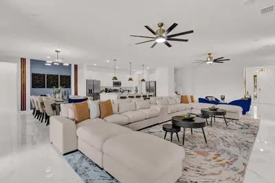 a living room with white furniture and a dining room at Luxury Home - ALL the extras - Sleeps 39 in Kissimmee