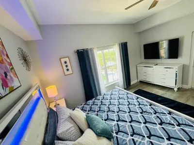 a bedroom with a bed and a tv in it at Luxurious & Epic Condo in heart of Orlando in Orlando