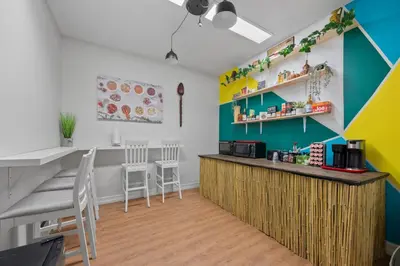 a kitchen with a counter and chairs in a room at Banana Leaf Villa in Orlando