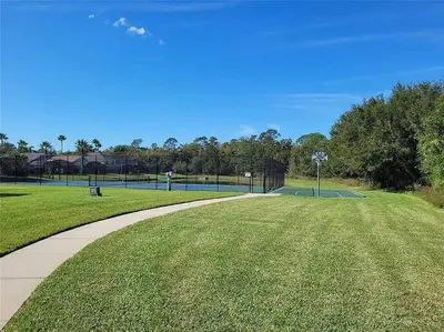 a walkway through a park with a tennis court at Elegance House in Kissimmee