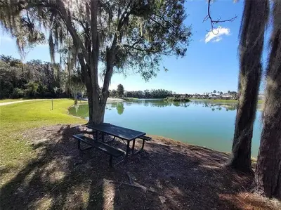 a park bench sitting next to a lake at Elegance House in Kissimmee