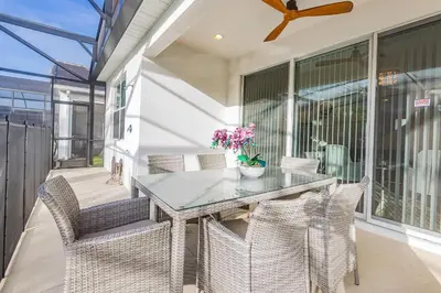 a dining room with a glass table and chairs at Fantastic 5 BD Pool Near Disney Resort Perks in Kissimmee
