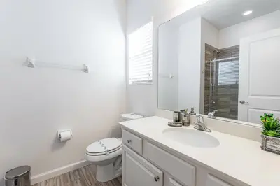 a white bathroom with a sink and a toilet at Fantastic 5 BD Pool Near Disney Resort Perks in Kissimmee