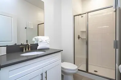 a bathroom with a toilet and a glass shower at Villa Smile - 4Q/3B Storey Lake *Casa Luxuosa* in Kissimmee