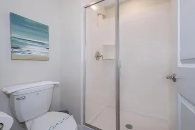 a white bathroom with a shower and a toilet at 4 BD 3 BA Private Pool Storey Lake 4832 in Kissimmee