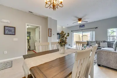 a dining room and living room with a dining table at Townhome 7 Mi to Disney Parks Resort Pool Access! in Kissimmee