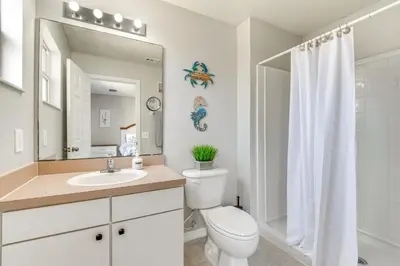 a bathroom with a toilet and a sink and a mirror at Townhome 7 Mi to Disney Parks Resort Pool Access! in Kissimmee