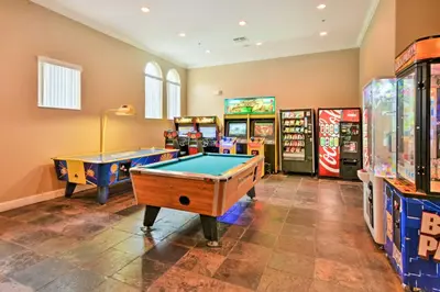 a game room with two pool tables and arcade machines at Townhome 7 Mi to Disney Parks Resort Pool Access! in Kissimmee