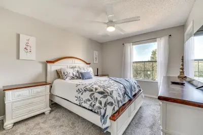a bedroom with a bed and a desk and a window at Townhome 7 Mi to Disney Parks Resort Pool Access! in Kissimmee