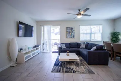 a living room with a blue couch and a table at Enchanted Orlando Getaway, 10 minutes from Disney in Kissimmee